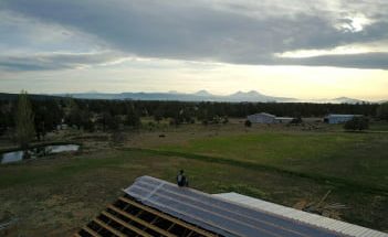 Pot For Planet_Vendor_Image green field with barns in foreground and mountains in background